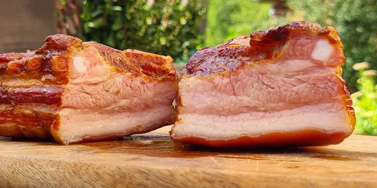 Smoked pork belly cut open on a wooden board