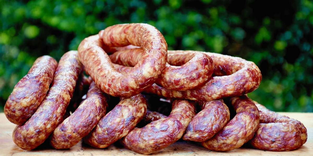 Smoked sausages on a wooden board outdoors